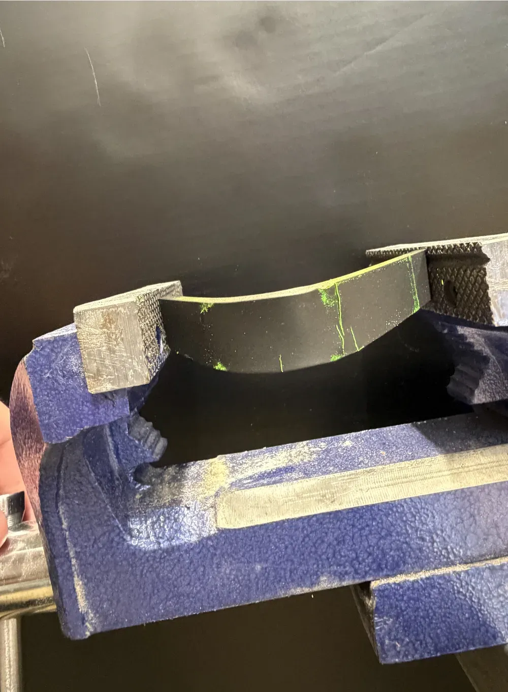 Coated bracket under UV with a fluorescent crack indication
