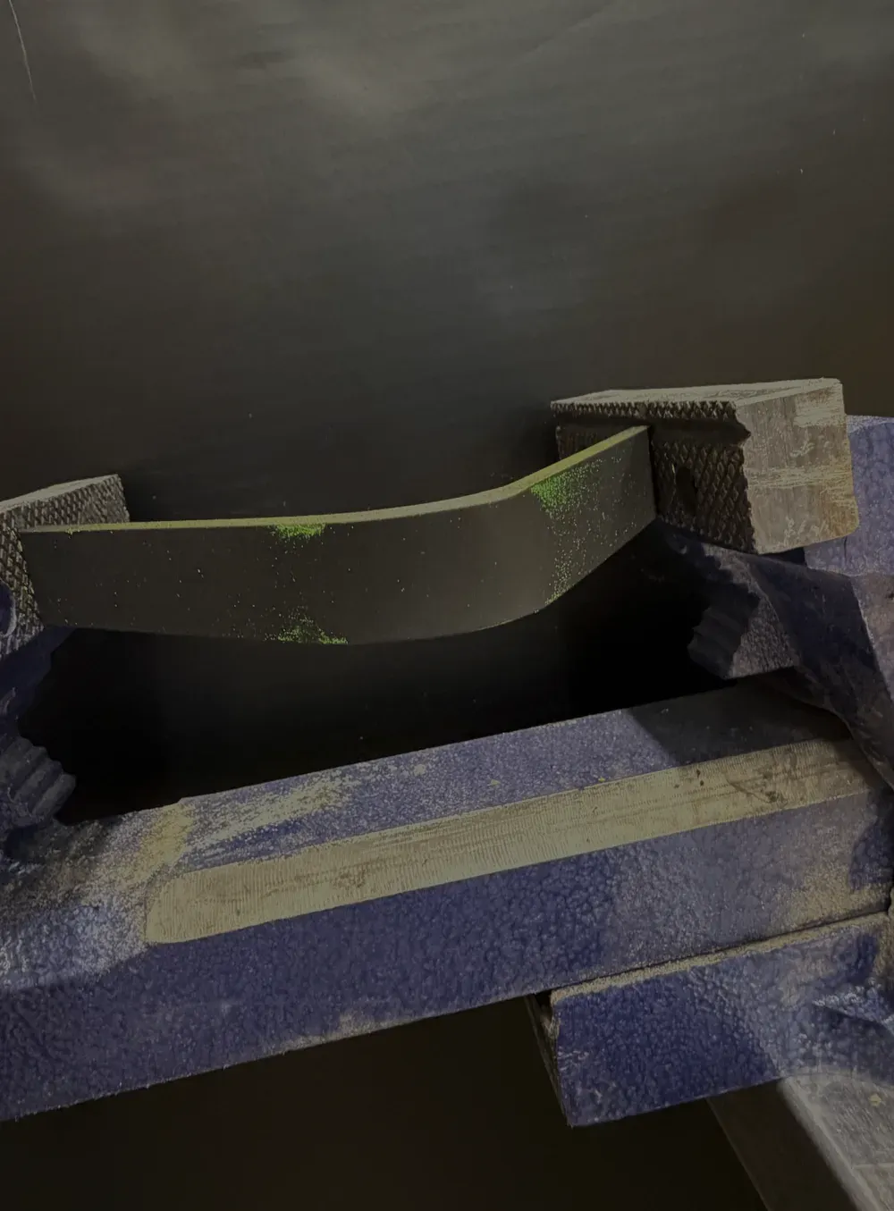 Coated bracket under UV showing coating wear but no crack